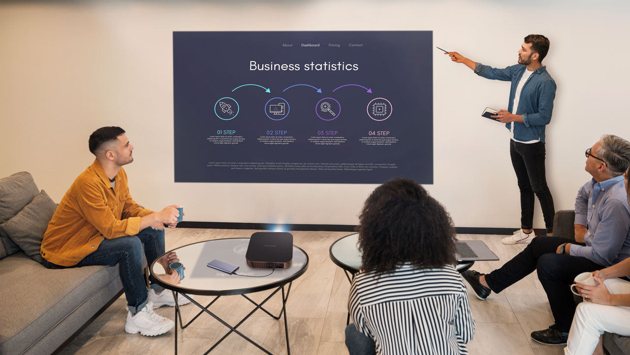 Team meeting using a business projector to display presentation slides in a modern office setting.
