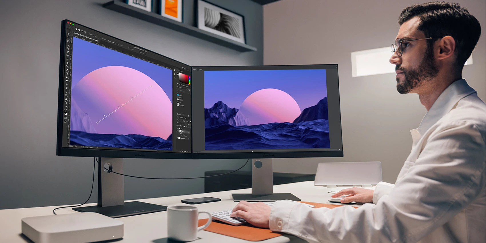 Professional working on a dual-monitor Mac Pro workstation with color-accurate displays in a modern studio setup