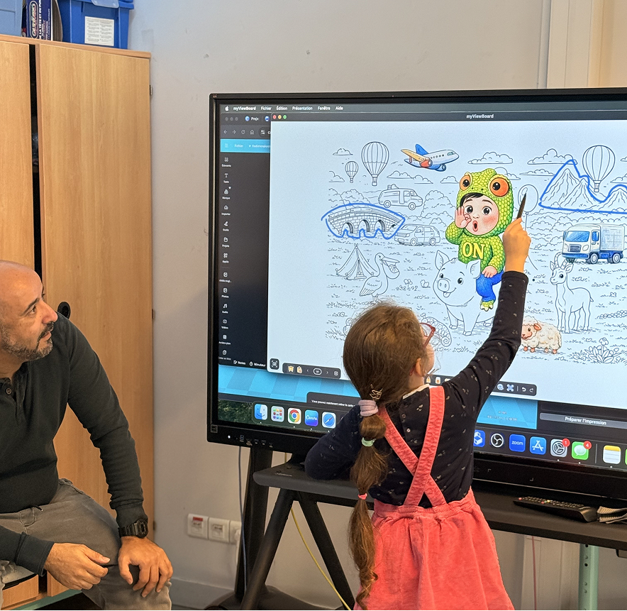 Activité pédagogique sur écran numérique interactif en classe de primaire, avec un élève interagissant avec le contenu et l’enseignant à ses côtés.