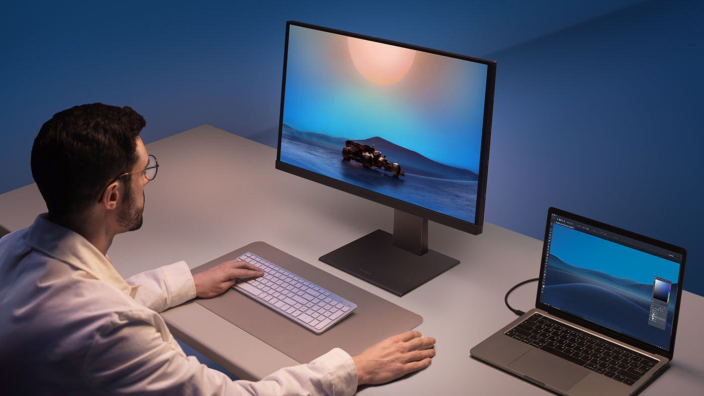 Creative using a MacBook Air, working at their desk.