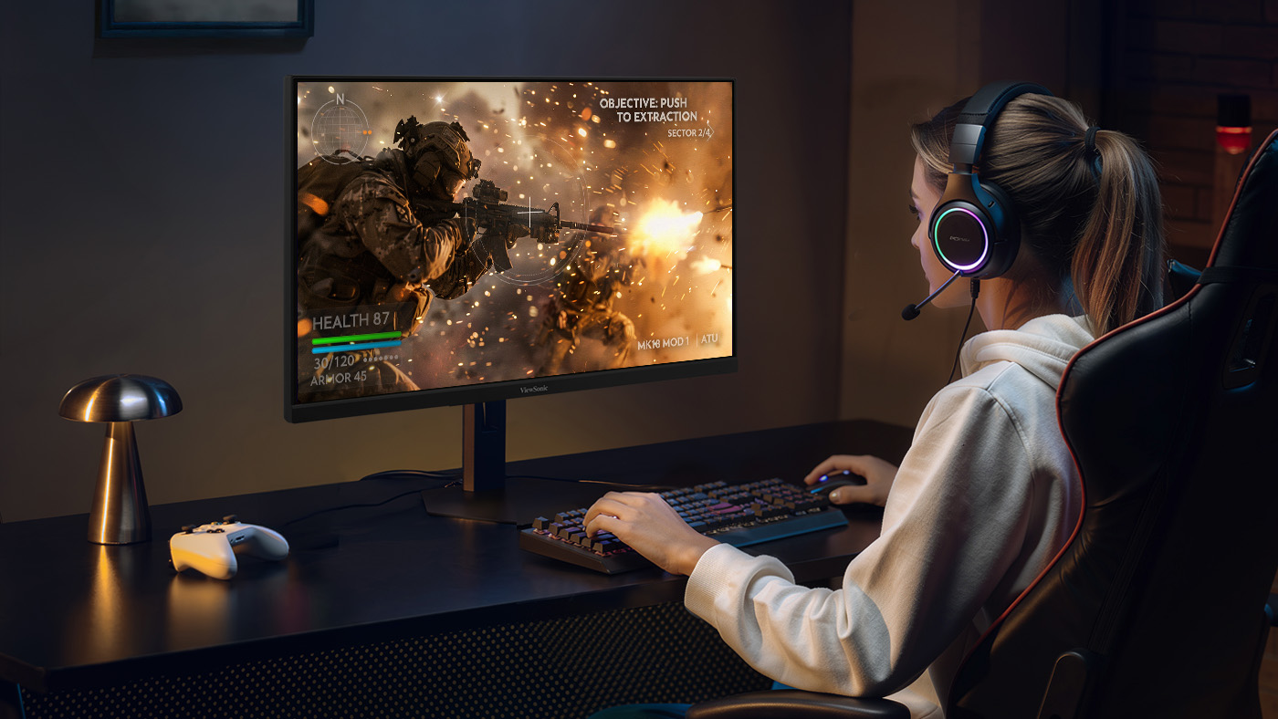 A blonde woman sitting in front of an OLED gaming monitor with fast response time
