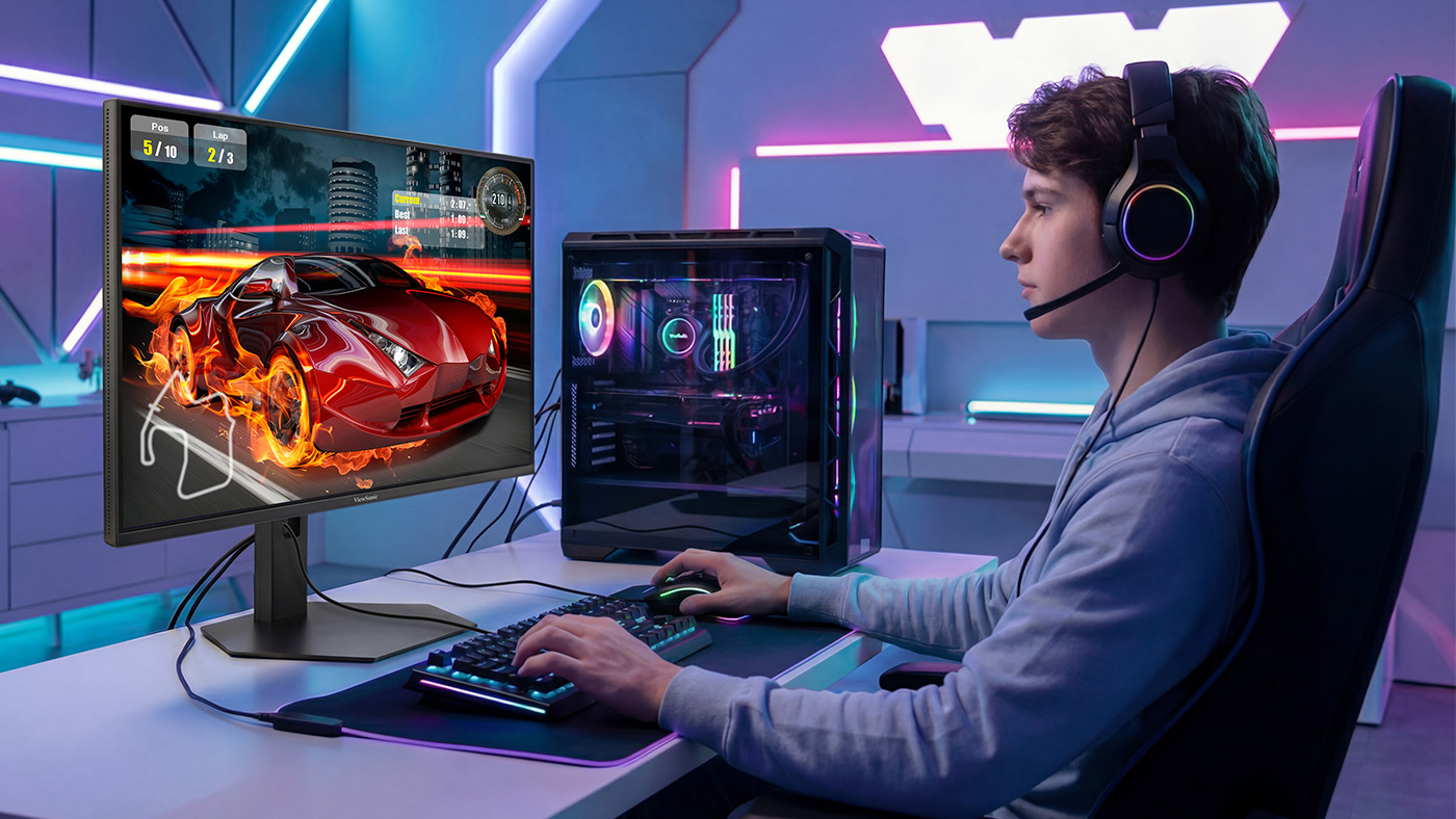 A boy in a blue sweater playing a racing game on an OLED gaming monitor with a fast response time.