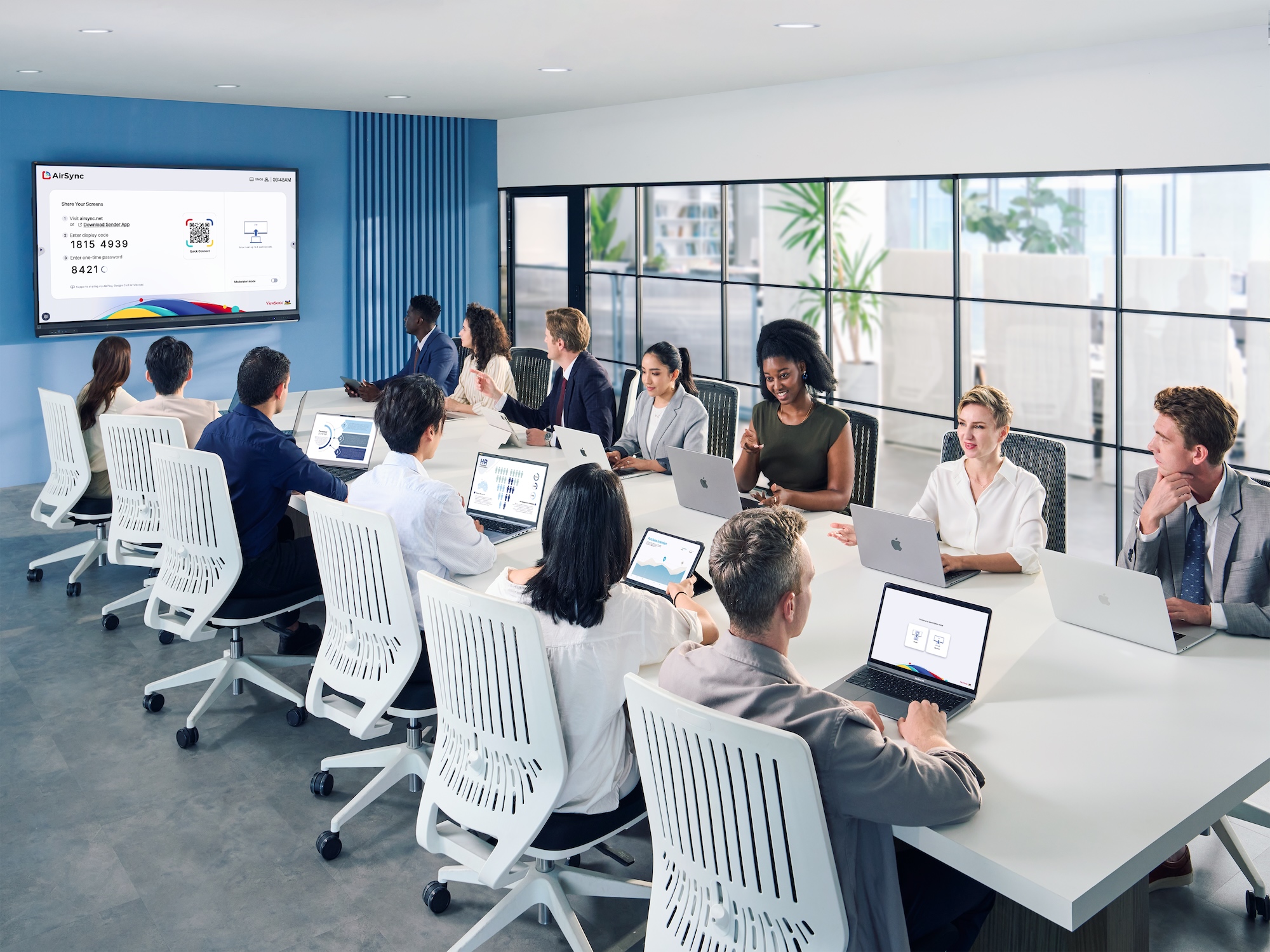 Colleagues gathered in a large meeting room with laptops and ViewSonic display solution.