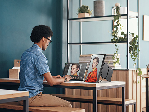 man working on a portable monitor from home