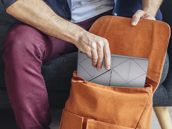 man putting the portable monitor into a travel bag