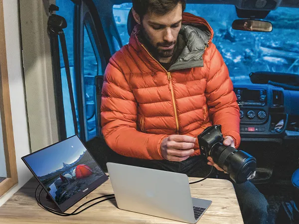 Photographer in a camper van with a VP16-OLED connected to his laptop