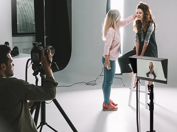 Photographer on set using VP16-OLED on a tripod as a visual monitor connected to his camera for photo review