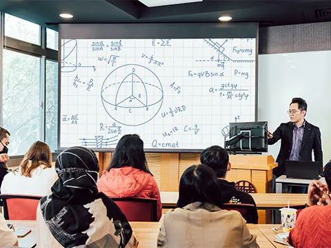 teacher using a ViewSonic ID2456 display and projector to instruct a room full of students