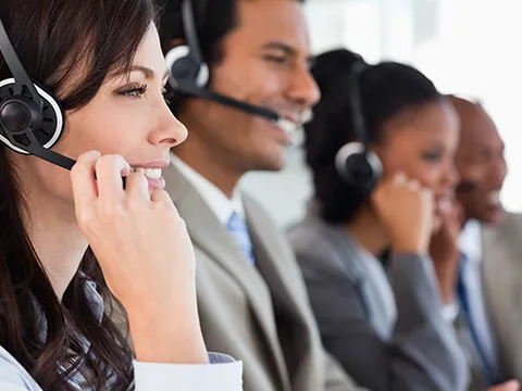 a row of smiling people wearing headsets