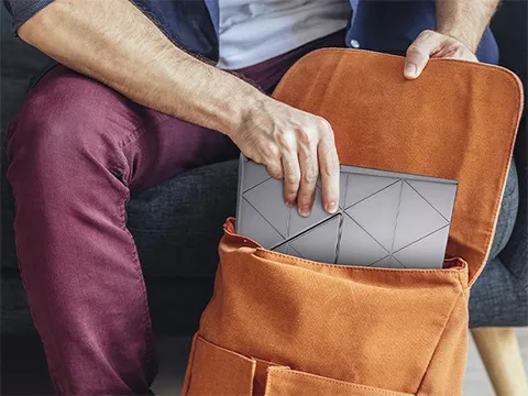 someone stowing a portable monitor in a bag