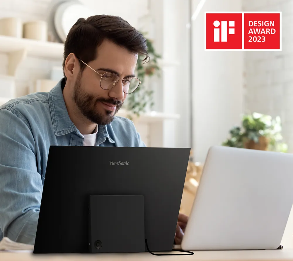 Man working on a laptop using the VX1655-4K-OLED. IF Design Award logo.