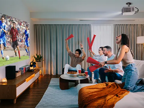 a group of people on a couch cheering for a soccer match