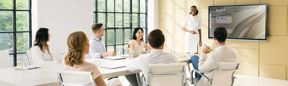 a businesswoman giving a presentation using a viewboard display in a conference room.