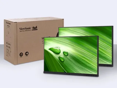 two monitors without stands next to a brown box