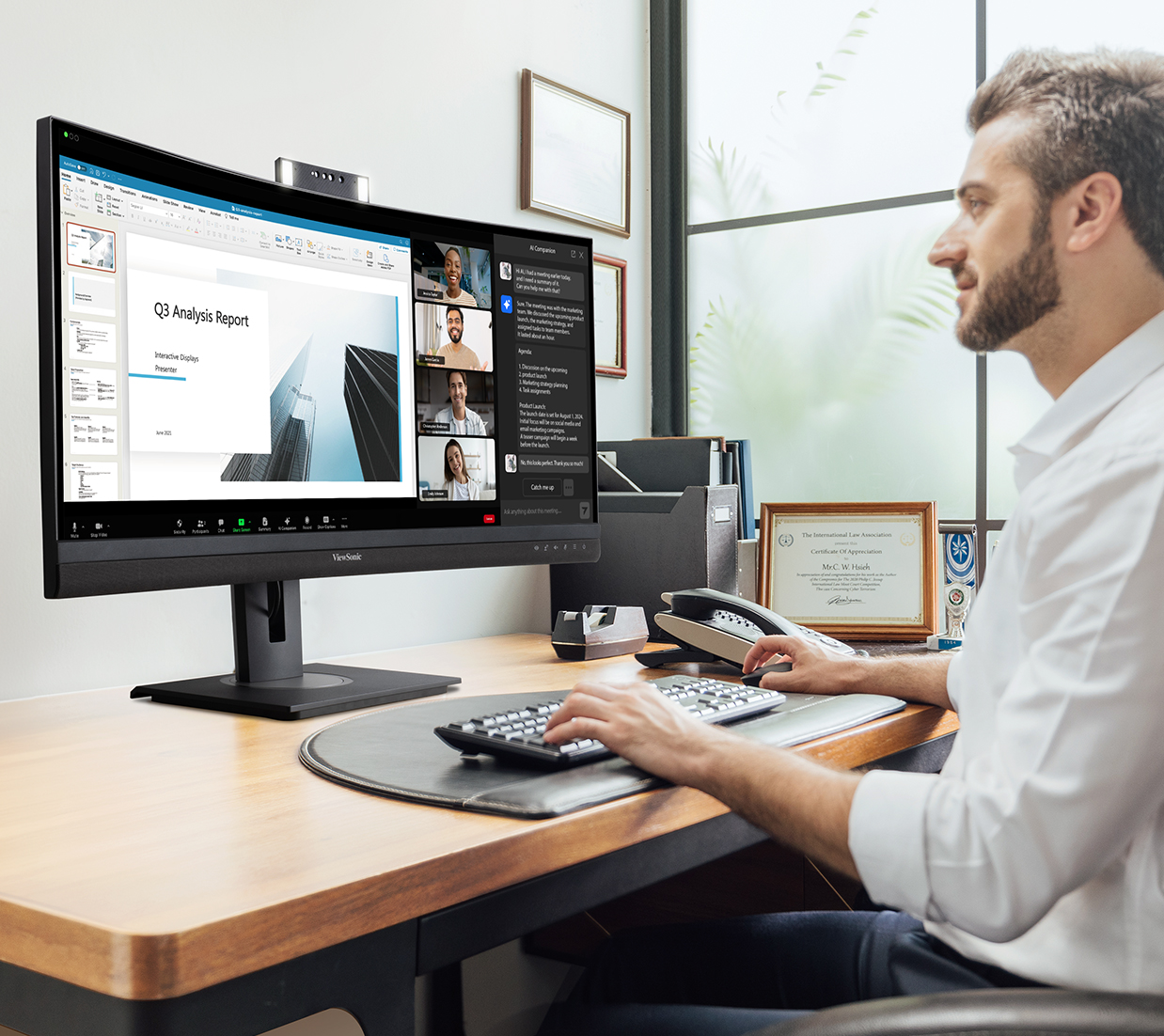 man working at desk, in a remote meeting using his curved monitor