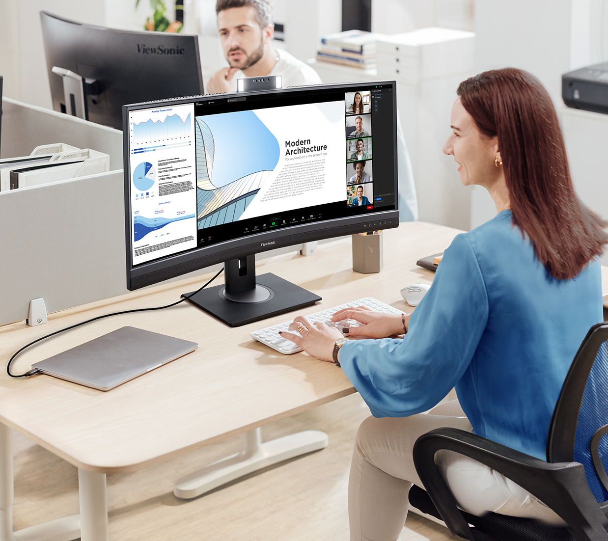 woman working at her desk in an office using a ultrawide curved monitor