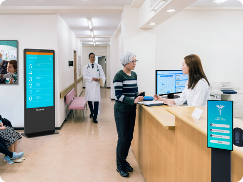 two women walking past a kiosk in a mall