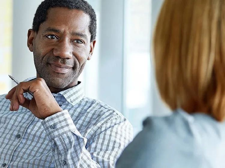 a man holding a pen engaged in conversation with a woman