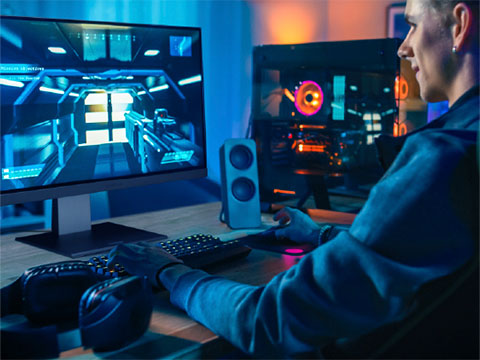 Man in a darker room using a ViewSonic gaming monitor to play video games