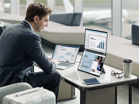 Professional man working remotely using ViewSonic portable monitors, laptops, and mobile devices in a cafe and flexible workspace.