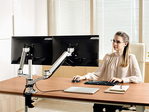 Business woman working at a desk on a dual ViewSonic monitor setup in a professional setting.