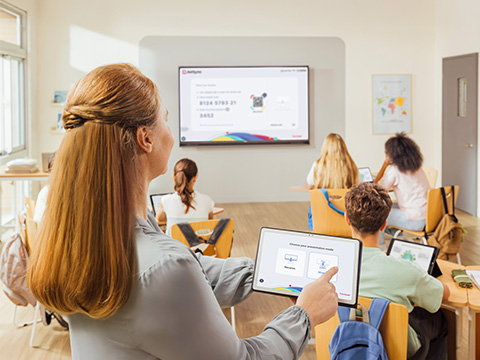 Instructor casting from her device in the back of a classroom on a podium and casting a to ViewBoard display