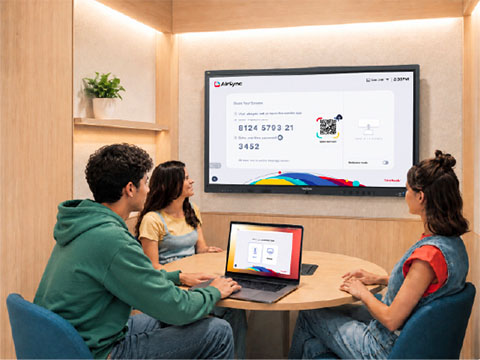 Instructor teaching to a classroom and hybrid students shown on the screen