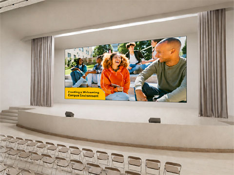 Instructor teaching to a classroom and hybrid students shown on the screen