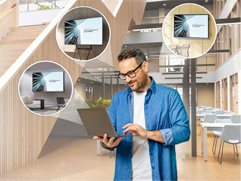 Instructor teaching to a classroom and hybrid students shown on the screen