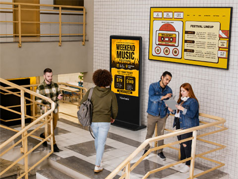 Student standing in the front of a classroom pointing to a ViewBoard