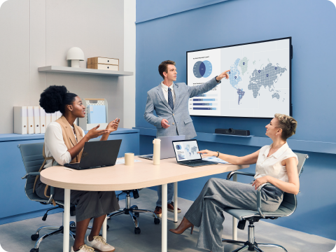 two screens on the wall of a conference room