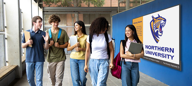 students walking through a hallway with a display on the wall