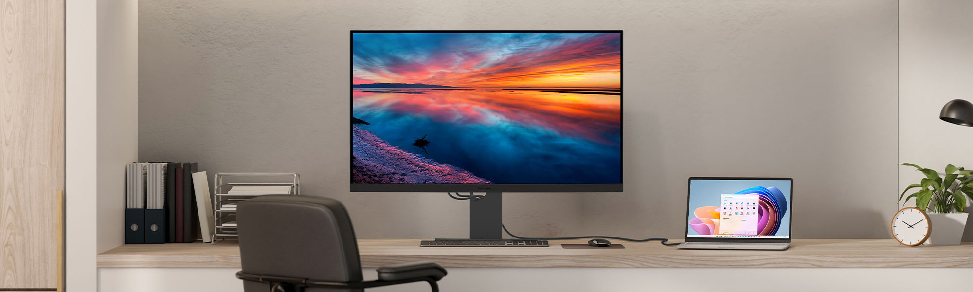a laptop connected to a large monitor both sitting on a desk