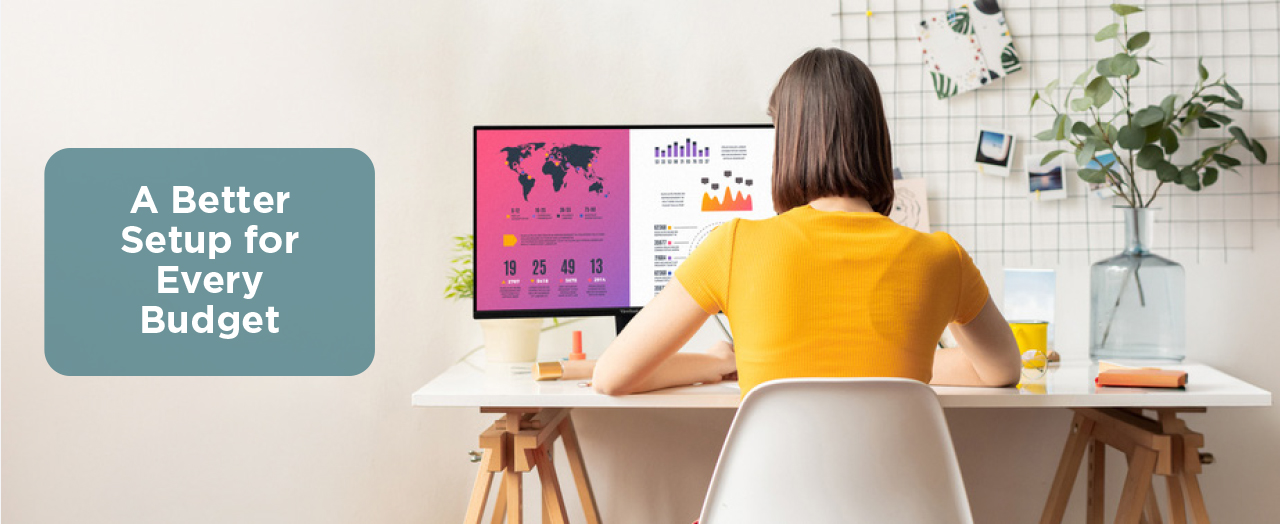 Woman sitting at a desk working on a monitor showing charts and graphs