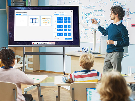 a teacher stands in front of a classroom motioning at a viewboard display