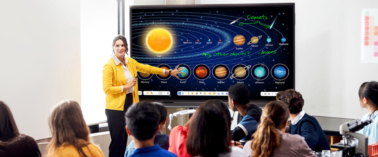 a teacher at the front of a classroom using the touch screen on a viewboard display to teach a lesson to a class full of students