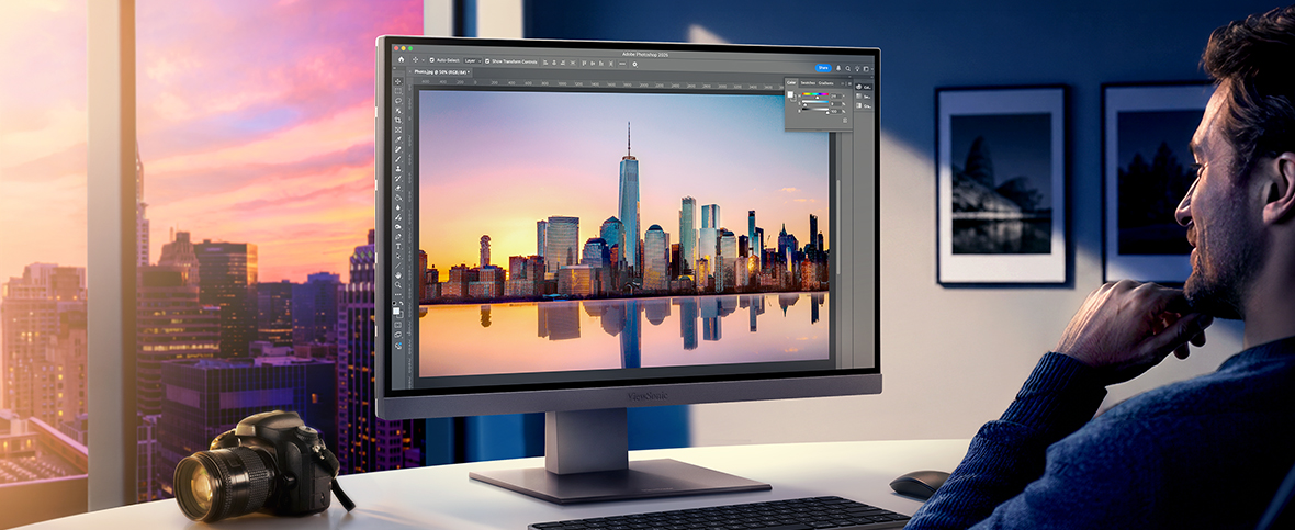 a man uses graphic design software on an ultrawide monitor
