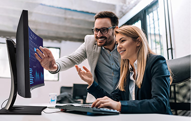 Two employees reviewing content on a ViewSonic curved monitor