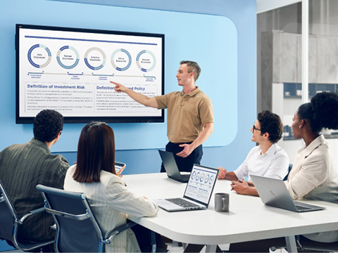 Man conducting a meeting in a smaller conference room, referencing a ViewBoard