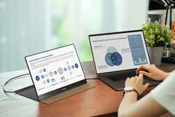 someone working on a laptop with a connected portable monitor