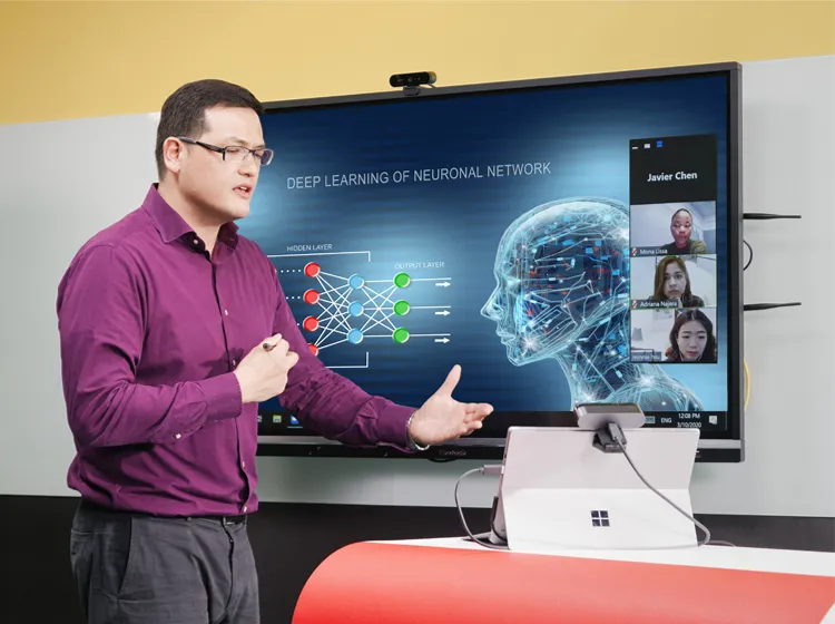 a teacher stands in front of a classroom with a viewboard in the background