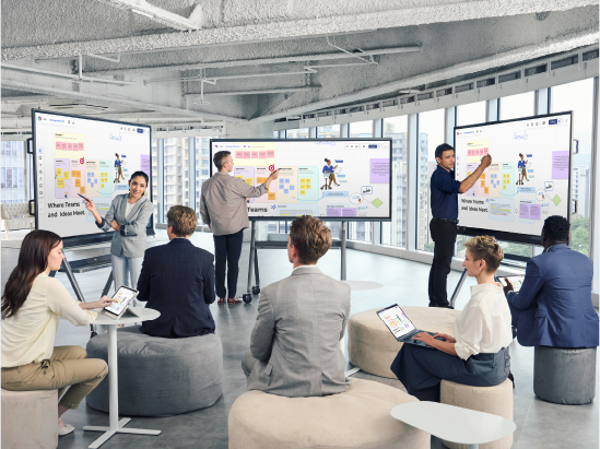 multiple people stand in front of a group presenting on separate viewboard displays
