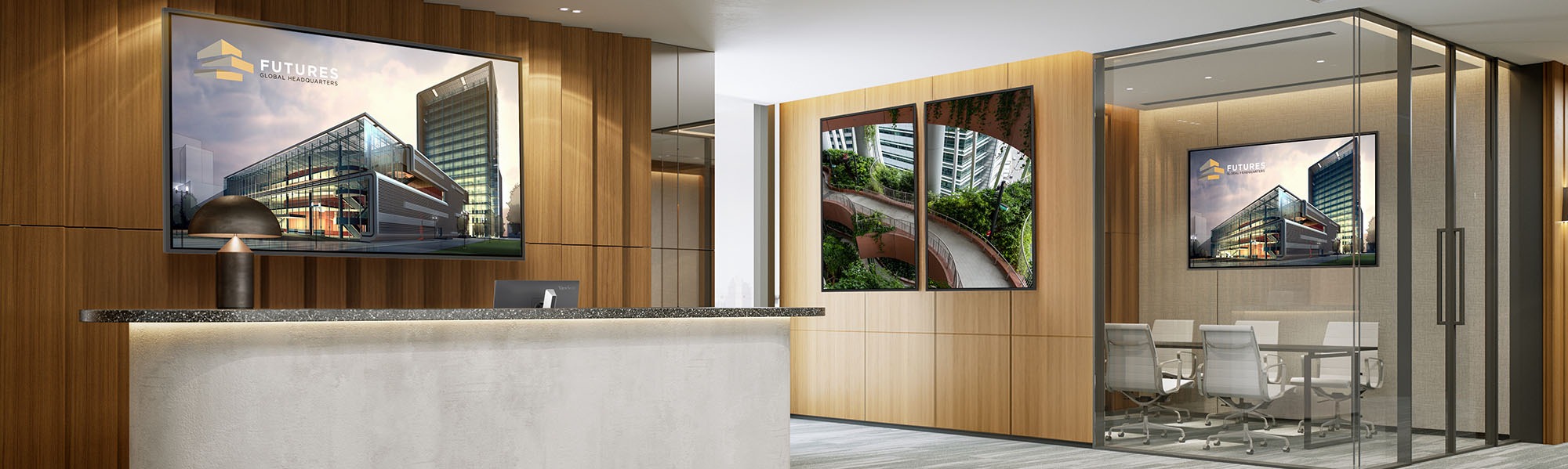 man standing and pointing to a CDE31 display with 2 women coworkers sitting at a table with laptops also looking at the CDE31