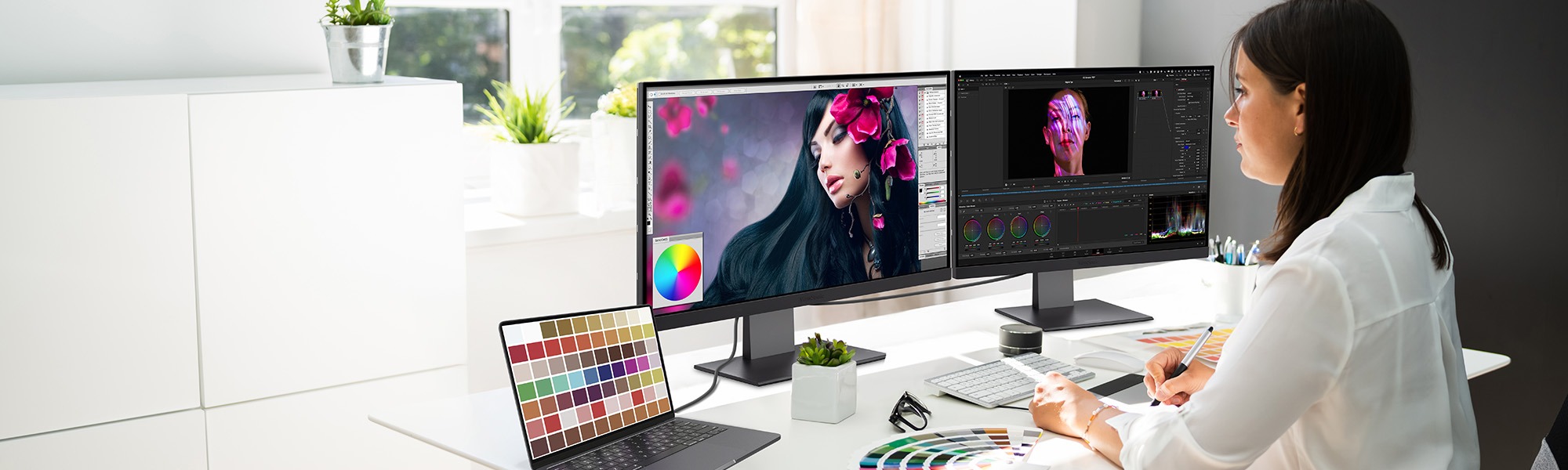 una mujer usa un software de diseño gráfico en dos monitores