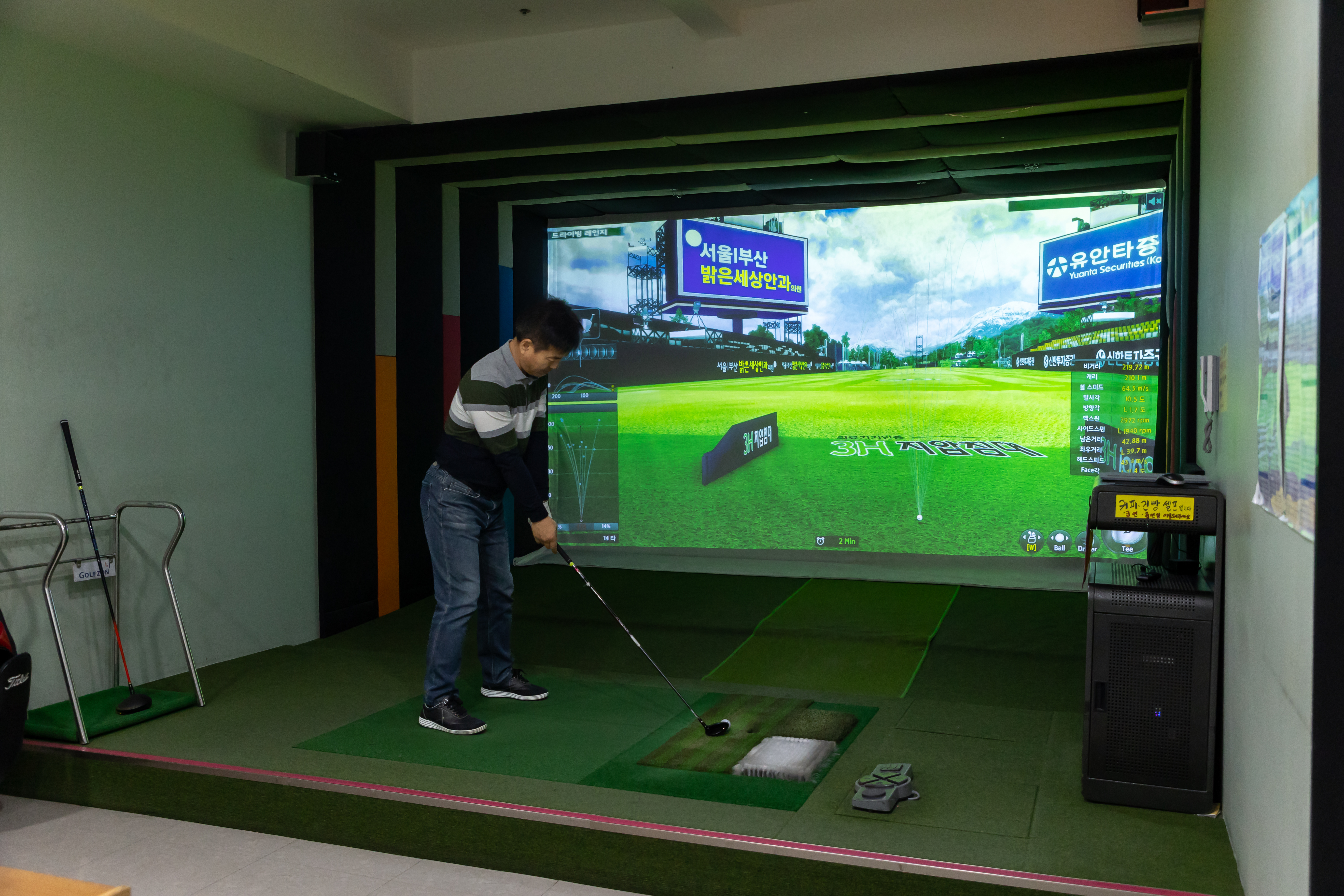 An immersive golf simulation setup in a Korean golf club, enabling year-round practice with high-quality projection.