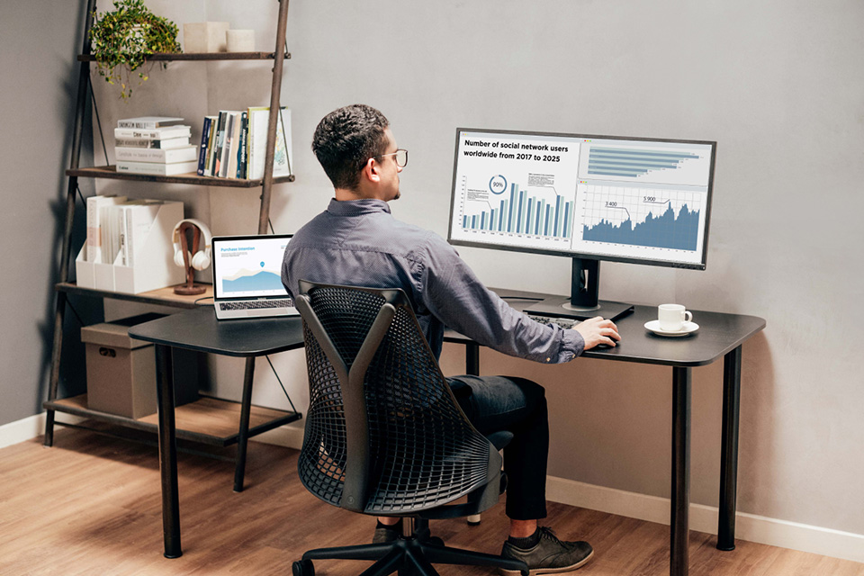 Man analyzing charts on a ViewSonic ultrawide monitor.