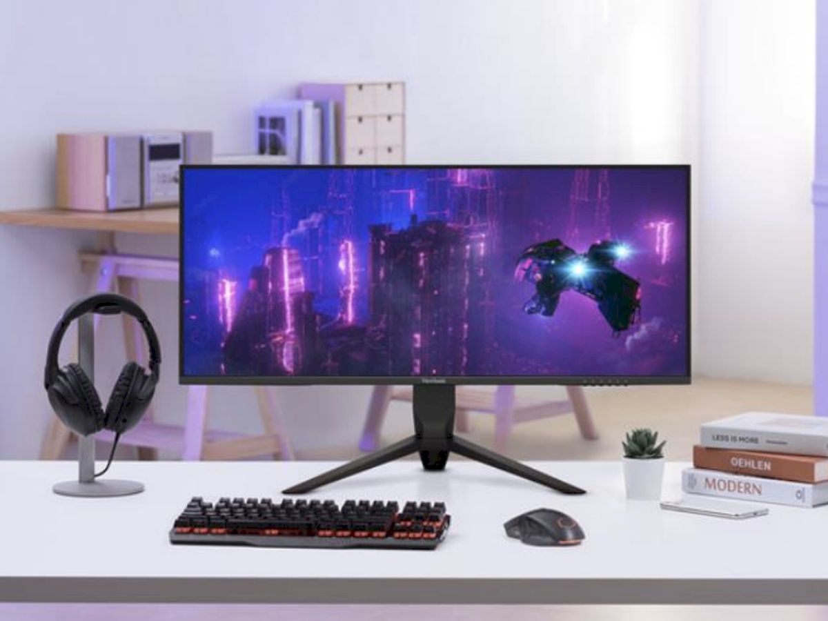 Moderne bureauopstelling met een ultrabrede monitor die een neon-cyberpunkscene weergeeft voor meeslepend gamen en creatief werk.